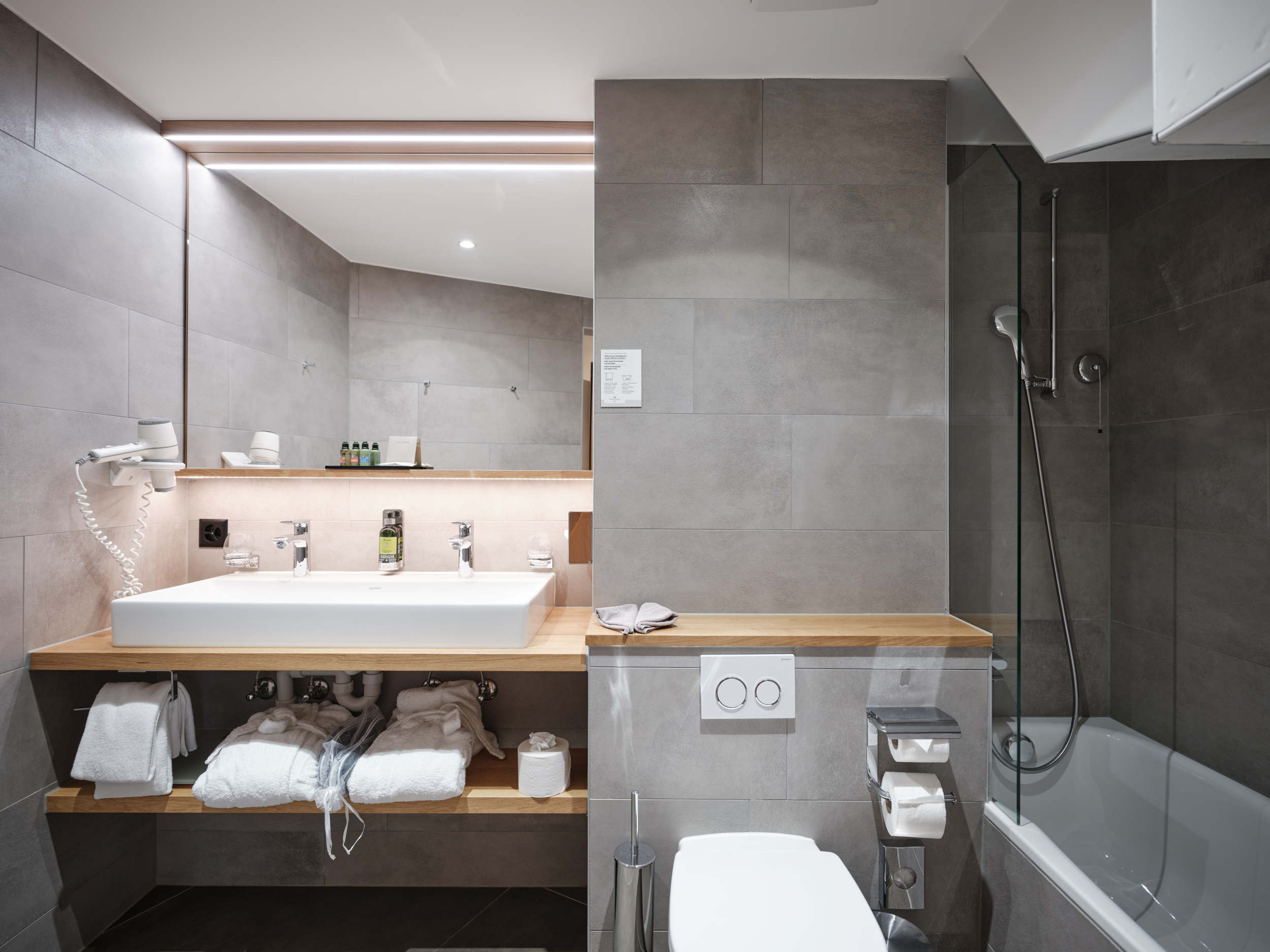 Modernes Badezimmer im Mini-Family-Zimmer im Hotel National Zermatt mit Dusche und Waschtisch