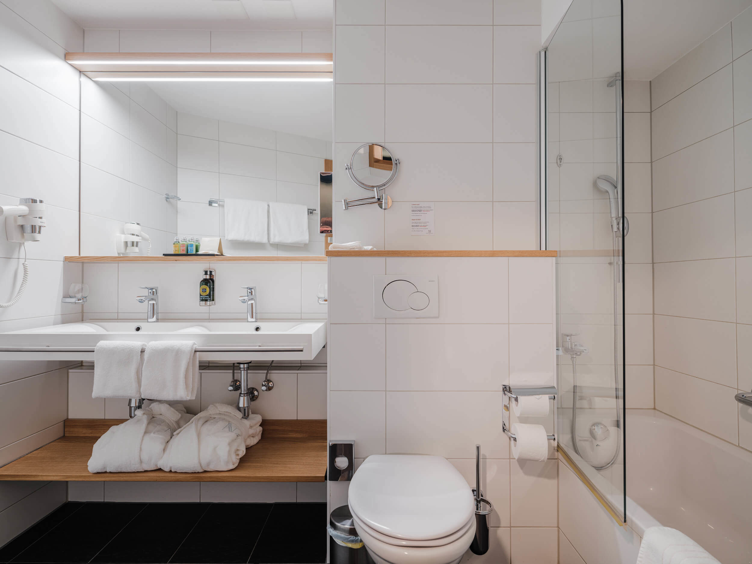 Modernes Badezimmer im Hotel National Zermatt mit Glasdusche und Waschtisch